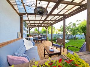 an outdoor patio with a wooden pergola at Alice Backyard Holiday Home - Apartments, Rooms & Exclusive Cave Saunas in Pärnu