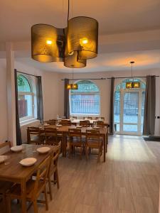 a dining room with wooden tables and chairs and windows at Shiro Nord in Predeal