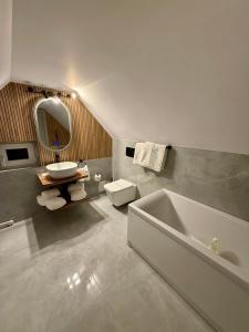 a bathroom with a white tub and a sink at Shiro Nord in Predeal +33 photos