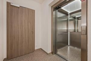 a closet with a wooden door and a refrigerator at Terrasse am Haff in Zirchow