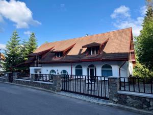 a house with a metal roof and a black fence at Shiro Nord in Predeal