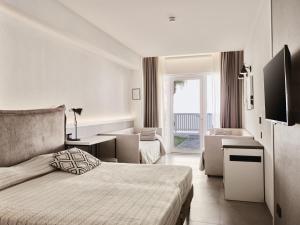 a bedroom with a bed and a living room at Mangia's Himera Resort in Campofelice di Roccella