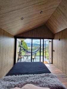 a bedroom with a bed and a large window at Vive Rela Tiny Houses in Nemocón