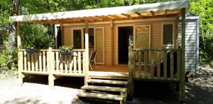 a small cabin with a porch and a deck at Les Acacias in Vercheny +110 photos