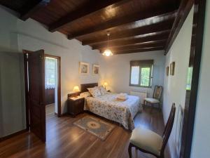 a bedroom with a bed in a room with wooden floors at Casa Nardo in Benia de Onís
