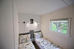 a small bedroom with a bed and a window at MOLO RESORT KEMPING in Osiek +35 photos