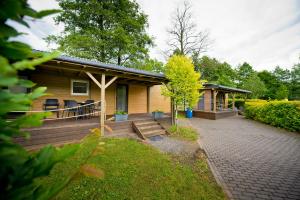 a wooden house with a porch and a patio at MOLO RESORT KEMPING in Osiek