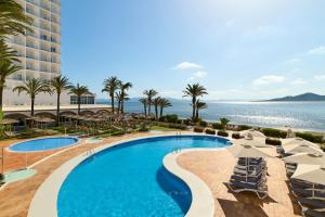 a pool with chairs and umbrellas at a resort at AluaSun Doblemar in La Manga del Mar Menor