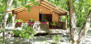 a small house in the woods with a porch at Les Acacias in Vercheny