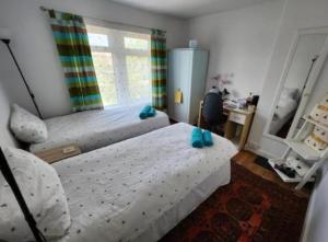 a bedroom with two beds and a desk and a window at BEE HAPPY available with shared bathroom in Glastonbury