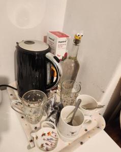 a tray with cups and a tea kettle on a counter at BEE HAPPY available with shared bathroom in Glastonbury