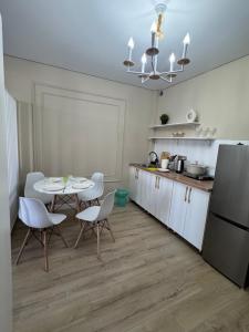 a kitchen with a table and chairs and a refrigerator at The Bay Apartments in Cholpon-Ata +15 photos