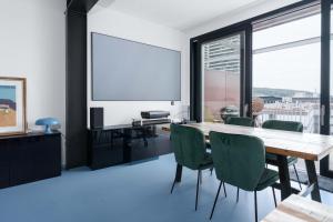a dining room with a table and chairs and a screen at Modern Zurich Apt with Balcony View & Workspace in Zurich