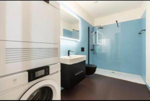 a bathroom with a sink and a washing machine at Modern Zurich Apt with Balcony View & Workspace in Zurich +17 photos