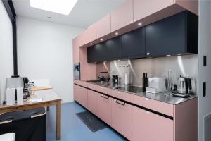 a kitchen with pink cabinets and a counter at Modern Zurich Apt with Balcony View & Workspace in Zurich