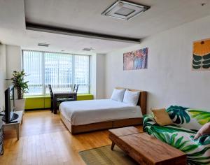a hotel room with a bed and a couch at Cozy - Bright Studio in Incheon