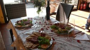 a table with two plates of food and wine glasses at Friulmarangon in Basiliano