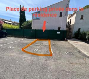 a parking lot with an orange painted arrow in front of a building at Vacances Cap d'Agde 1 chambre, 1 mezzanine, parking et piscine in Cap d'Agde