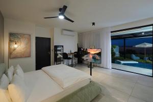 a bedroom with a bed and a flat screen tv at Y HOUSE SUITES in Mishmār Hāyardin