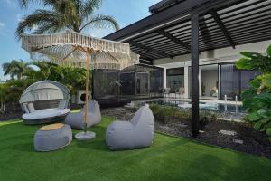 a house with chairs and an umbrella in the yard at Y HOUSE SUITES in Mishmār Hāyardin
