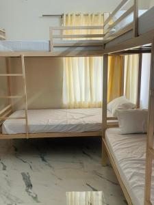 a bedroom with two bunk beds with white sheets at Zenways in Varkala +32 photos