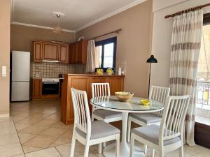a kitchen with a table and chairs and a kitchen with a refrigerator at Lemon & Light Bright Apartment with View and Fireplace in Meligalás