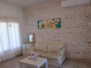 a living room with a couch and a brick wall at Hospedaje El Ciruelo in Alta Gracia +22 photos