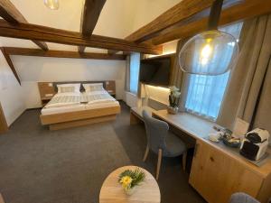 a bedroom with a bed and a desk and a table at Gästehaus Klingler in Besigheim