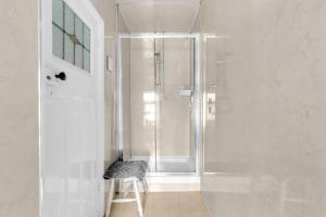 a white bathroom with a shower and a stool at Mallowview guest house in Cleethorpes +66 photos