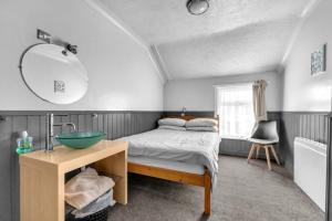 a bedroom with a bed and a sink and a mirror at Mallowview guest house in Cleethorpes