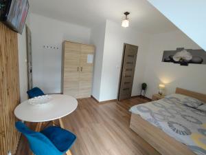 a bedroom with a bed and a table and chairs at Noclegi Pod Lasem in Polańczyk