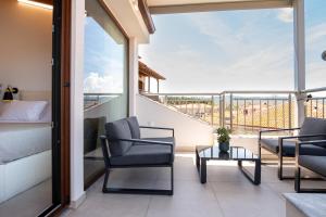 a balcony with two chairs and a bed and a table at Kallisti Luxury Rooms in Ierissos