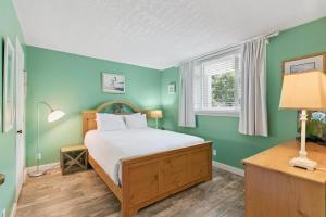 a bedroom with green walls and a bed and a window at North Breakers - Unit 202, Wood Ave in East End +18 photos