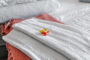 a white bed with white towels with flowers on it at Apartament de închiriat in Borsec