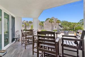 a group of chairs sitting on the porch of a house at North Breakers - Unit 202, Wood Ave in East End