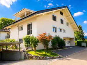 a white house with a tree in front of it at Skender's Apartment in Interlaken