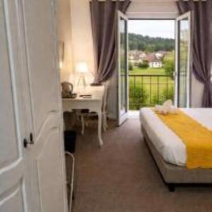 a bedroom with a bed and a desk and a window at Hôtel de Charme By Arts & Millésimes in Essoyes +15 photos