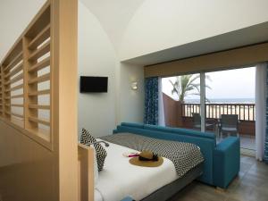 a bedroom with a bed and a view of the ocean at Novotel Marsa Alam Beach Resort in Quseir