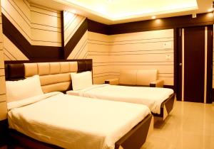 a hotel room with two beds in a room at Hotel S G International in Dhanbād