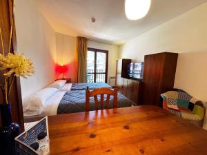a bedroom with a bed and a table in a room at Apartamentos Los Lagos in Benasque