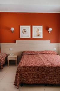a bedroom with a bed and two pictures on the wall at Hotel Marina in Lido di Jesolo +77 photos