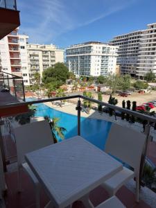 a balcony with a table and a view of a pool at Shengjin Paradise Apartment in Shëngjin