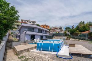a blue container sitting on the ground in front of a house at Villa Viola in Lovran