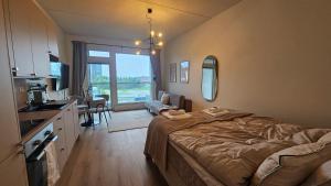 a bedroom with a bed and a kitchen with a sink at Fabbrica's new and elegant apartment in Turku