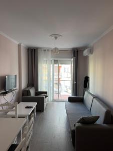 a living room with a couch and a tv at Shengjin Paradise Apartment in Shëngjin
