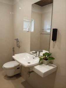 a white bathroom with a toilet and a sink at Pekoe Bungalow Bambarakanda Waterfall and Pekoe Trail Retreat in Welegama
