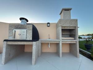 a stone pizza oven sitting on top of a patio at Casinhas do Penedo in Canelas