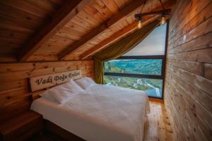 a bed in a wooden room with a window at Vadi Ahşap Doğa Evleri in Ardeşen