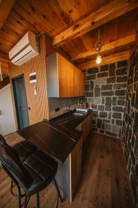 a kitchen with a counter top and a stone wall at Vadi Ahşap Doğa Evleri in Ardeşen