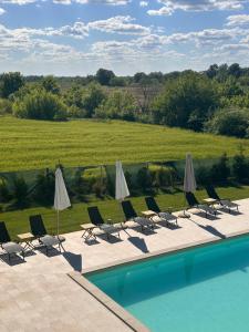 a group of chairs and umbrellas next to a swimming pool at Hedona227 in Perlez